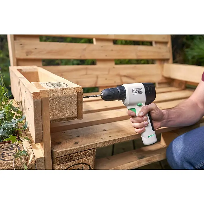 Black+Decker reviva Taladro atornillador de batería - 12 V, 1 batería, 1,5 Ah, 26 Nm - Perforación en un mueble de palets de madera con el taladro inalámbrico Black+Decker. La herramienta permite un trabajo preciso y fácil.