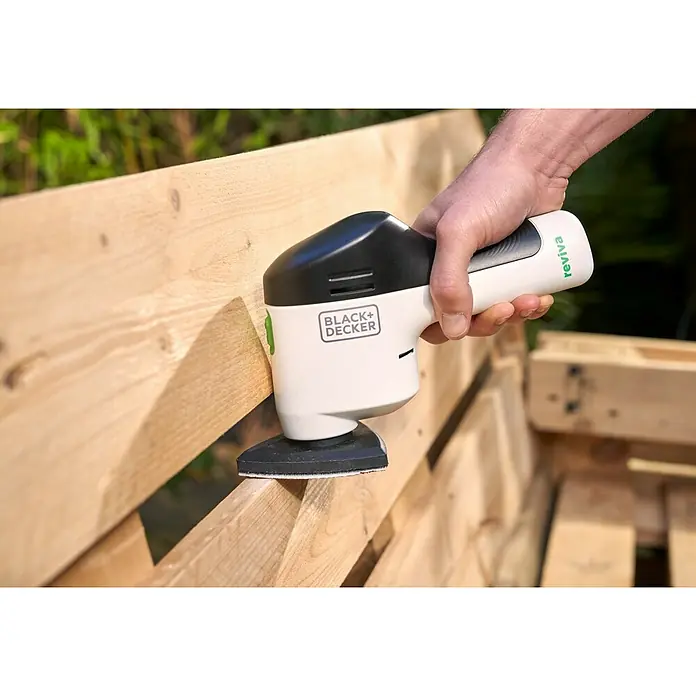 Black+Decker reviva Lijadora delta de batería - 12 V, 1,5 Ah, 11.000 r.p.m. - Primer plano de una lijadora Black+Decker Reviva suavizando una superficie de madera, sostenida por una mano.