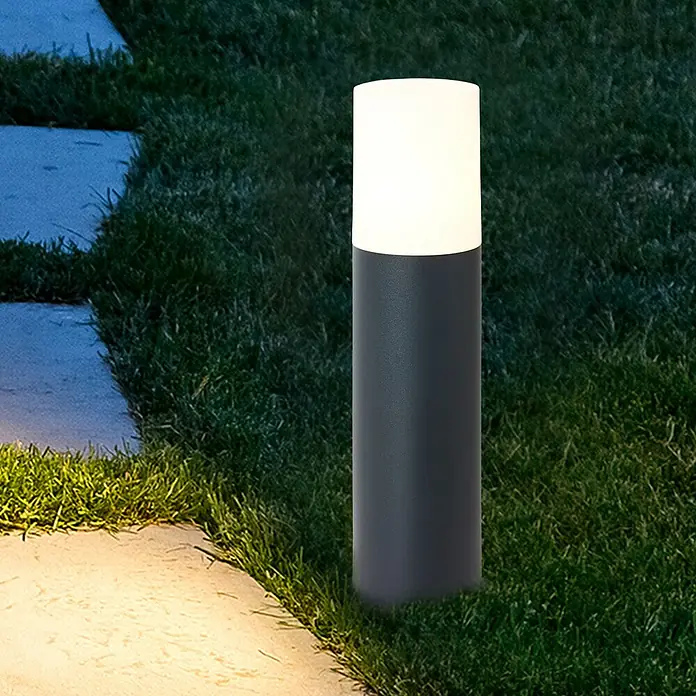Brilliant Außensockelleuchte - 28 W, Farbe Gehäuse: Anthrazit, Ohne Leuchtmittel - Nahaufnahme einer modernen grauen Gartenleuchte mit einem hellen, zylindrischen Diffusor, platziert in einem gepflegten Gartenbereich.