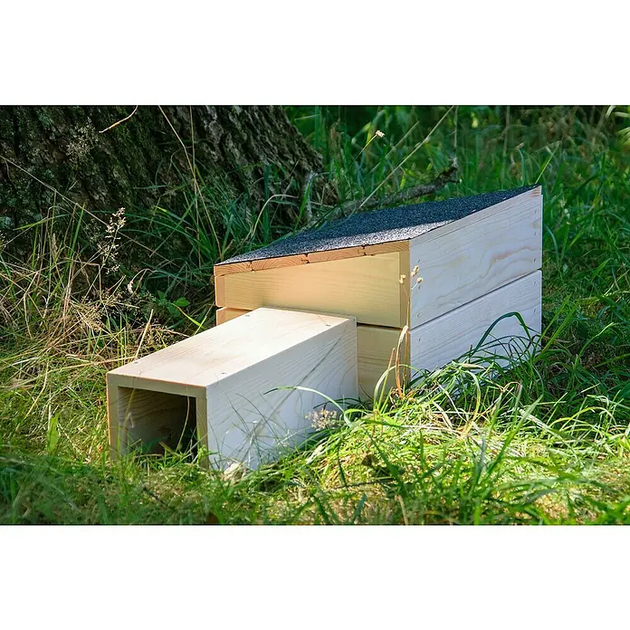 Dobar Igelhaus - 74,5 x 29 x 24 cm, Holz, Braun/Schwarz - Detaillierte Ansicht eines hölzernen Fledermauskastens mit geneigtem Dach, platziert im Gras neben einem Baumstamm.