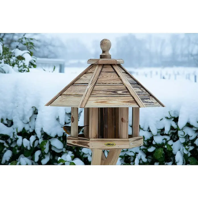 Dobar Vogelfutterhaus Brillo - L x B x H: 45 x 45 x 47 cm, Braun, Holz - Winterliches Vogelhaus mit einem kleinen Vogel, der Futter sucht. Die Holzkonstruktion ist schneebedeckt und bietet einen sicheren Futterplatz.