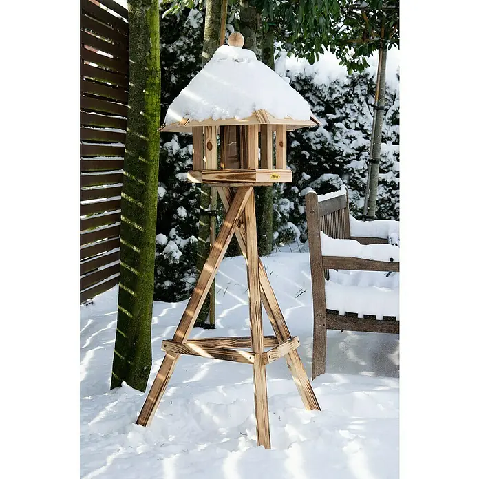 Dobar Vogelhausständer - L x B x H: 60 x 60 x 90 cm, Kiefer, Braun - Holzvogelhaus auf einem Ständer im Schnee. Das Vogelhaus ist mit Schnee bedeckt und steht in einem Garten.