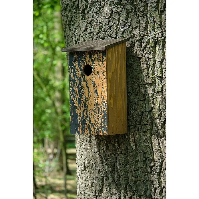 Dobar Nistkasten - L x B x H: 15,5 x 14,5 x 30 cm, Braun, Holz - Ein hölzernes Vogelhaus mit Tarnmuster ist an einem Baum befestigt, umgeben von Laub. Bietet Schutz und Nistplatz für Vögel im Garten.