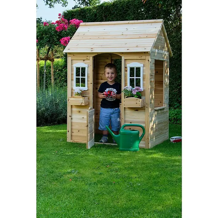 Dobar Spielhaus - L x B x H: 107 x 92 x 144,5 cm, Holz, Natur - Ein Kind steht in einem hölzernen Spielhaus mit Blumenkästen unter den Fenstern. Eine grüne Gießkanne steht davor.