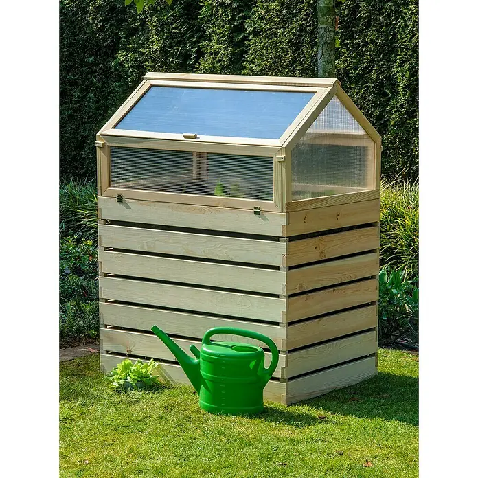 Dobar Hochbeet Hathi - L x B x H: 100 x 70 x 130 cm, Holz, Natur - Ein hölzernes Hochbeet mit transparentem Deckel, ideal für den Garten oder Balkon, steht neben einer grünen Gießkanne auf dem Rasen.