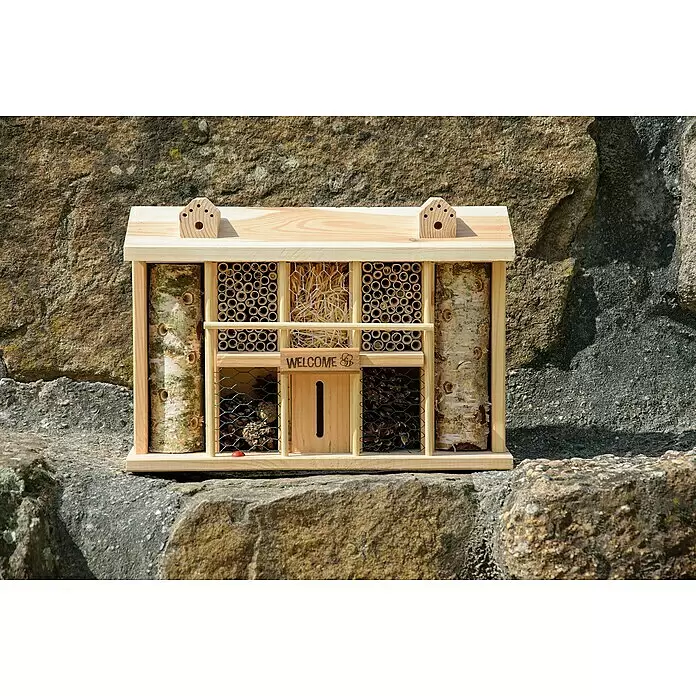 Dobar Insektenhotel Alabama - 44 x 13,5 x 30 cm, Kiefer, Natur - Hölzernes Insektenhotel mit mehreren Fächern und Naturmaterialien, auf einer Steinmauer.