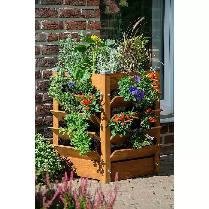 Dobar Komposter und Hochbeet 3-in-1 - 180 l, 64,5 x 64,5 x 75,5 cm - Vertikales Holz-Pflanzgefäß, gefüllt mit Kräutern, Paprika und Blumen, steht draußen an einer Backsteinmauer.