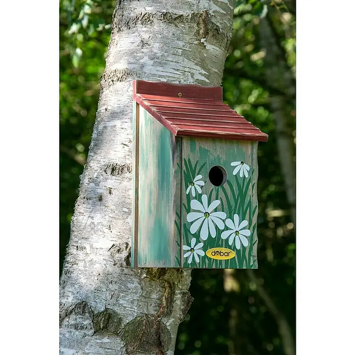 Dobar Nistkasten - L x B x H: 15 x 14,5 x 28 cm, Rot/Blau/Grün, Holz - Ein charmantes Vogelhaus mit Gänseblümchen-Design, gefertigt aus Holz und mit rotem Dach, hängt an einem Baumstamm.