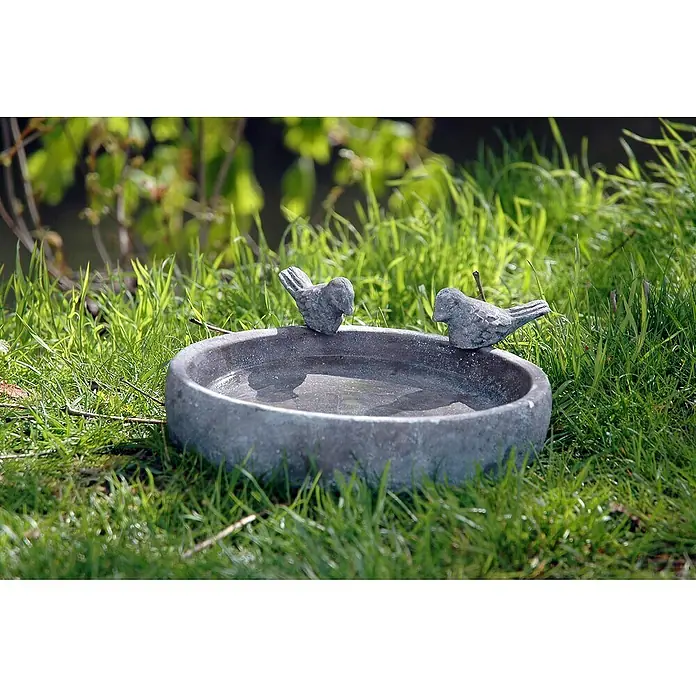 Dobar Vogeltränke Pool-Oase - Grau, Ø x H: 18 x 4,5 cm, Keramik - Nahaufnahme einer Vogeltränke mit zwei Vogelornamenten aus Stein, umgeben von saftigem, grünem Gras im Garten.