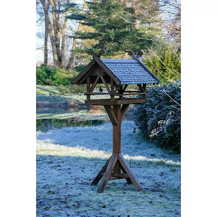 Dobar Vogelfutterhaus Westfalen - 78 x 62 x 148 cm, Grün/Braun, Holz - Braunes hölzernes Vogelhaus mit Spitzdach, in einem frostigen Garten mit kleinen Vögeln.