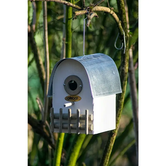 Dobar Nistkasten Rundhaus - 14 x 20 x 22 cm, Holz, Weiß/Silber - Nahaufnahme eines weißen "debar" Vogelhauses mit einem Metalldach, das an einem Baum hängt.