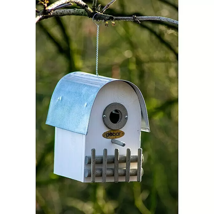Dobar Nistkasten Rundhaus - 14 x 20 x 22 cm, Holz, Weiß/Silber - Ein weißes Vogelhaus aus Holz mit silbernem Metalldach, das an einem Ast hängt.