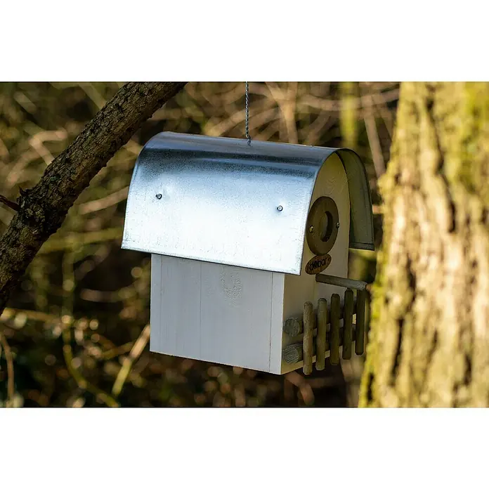 Dobar Nistkasten Rundhaus - 14 x 20 x 22 cm, Holz, Weiß/Silber - Ein weißes Vogelhaus mit einem Metalldach, das an einem Baum hängt. Das Vogelhaus hat einen kleinen Zaun und ein rundes Eingangsloch.