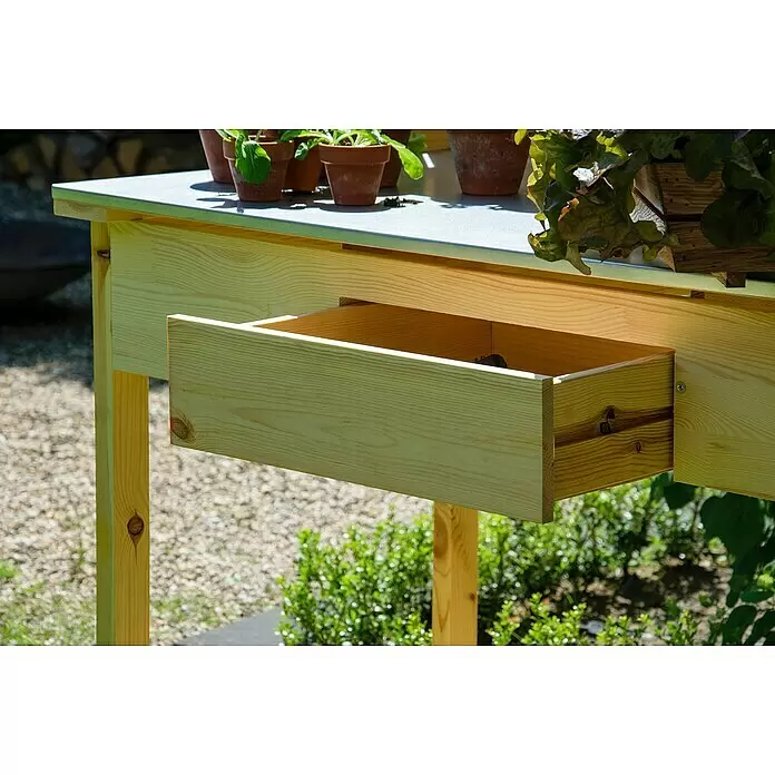 Dobar Pflanztisch Buche - L x B x H: 117 x 62 x 124 cm - Helle Gartenwerkbank aus Holz mit Metallplatte und geöffneter Schublade im Garten.