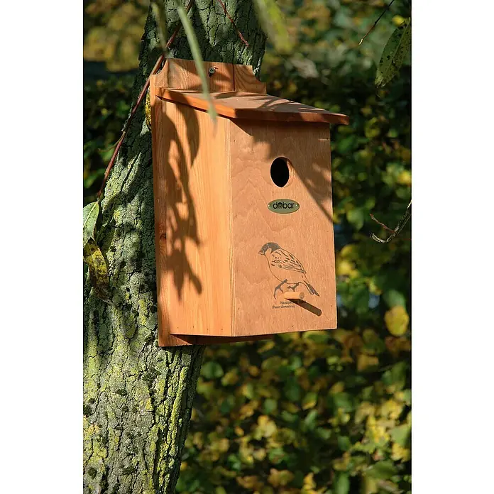 Dobar Nistkasten - L x B x H: 30 x 18 x 22,5 cm, Braun, Holz - Ein hölzernes Vogelhaus mit einem Einflugloch und einer Abbildung eines Vogels, befestigt an einem Baumstamm im Freien.
