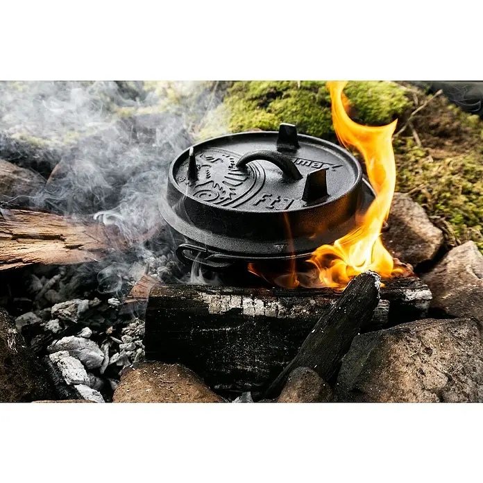 Petromax Dutch Oven - Ø x H: 25,2 x 16 cm, Gusseisen, 1,6 l, Mit Füßen - Dutch Oven auf offenem Feuer mit Rauch und Flammen, ideal für Outdoor-Küche.