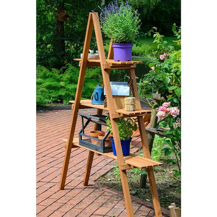 Dobar Dekoleiter - L x B x H: 120 x 28 x 150 cm - Dekoratives Holzregal mit Pflanzen in bunten Töpfen und anderen Gartenaccessoires auf einem gepflasterten Gartenweg.