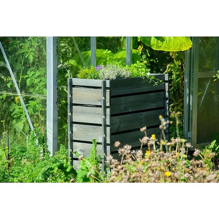 Dobar Hochbeet Stecksystem - L x B x H: 79 x 37 x 79 cm, Holz, Anthrazit - Der erhöhte Pflanzkasten aus Holz ist mit verschiedenen grünen Pflanzen und Kräutern bepflanzt und steht vor einem Gewächshaus.