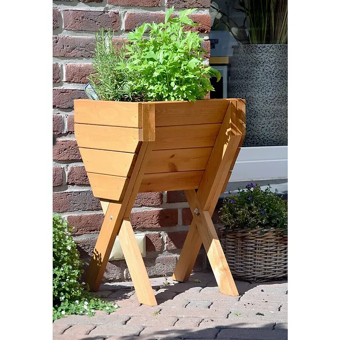 Dobar Hochbeet - L x B x H: 39 x 40 x 61 cm, Holz, Braun - Ein hölzerner Pflanzkasten mit Kräutern steht vor einer Ziegelwand, ideal für Gartenliebhaber. Robust und dekorativ für den Außenbereich.