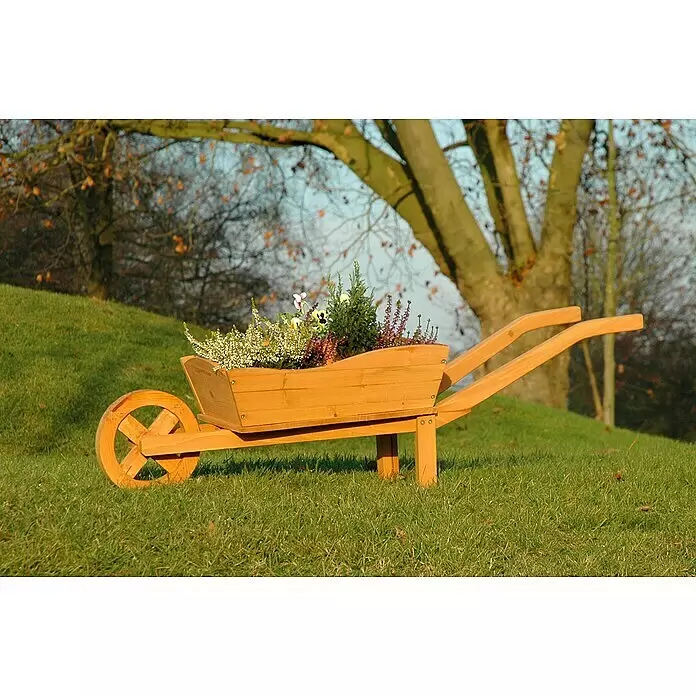 Dobar Pflanzkasten Pflanzkarre - L x B x H: 107 x 29 x 30 cm - Dekorativer Holz-Schubkarren als Pflanzgefäß, gefüllt mit kleinen Pflanzen, auf einem Rasenhügel.