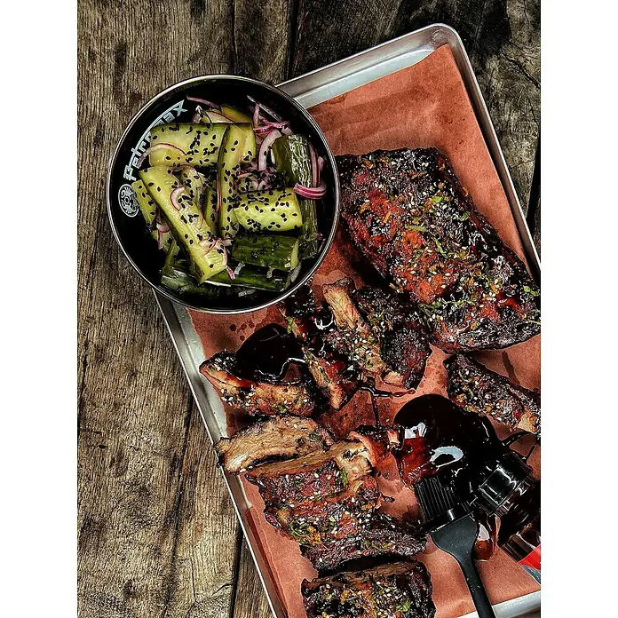 Petromax Schale - Schwarz, 500 ml, Emailliert, 2 Stk. - Köstliche Rippchen mit Gurkensalat auf einem Serviertablett, perfekt für ein Barbecue oder ein gemütliches Abendessen.