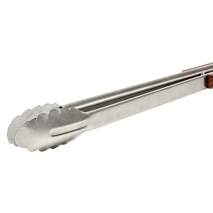 Petromax Grillzange - Länge: 54 cm - Nahaufnahme einer Metallzange mit gewelltem Rand und Holzgriff auf schwarzem Hintergrund, die ein Küchenutensil zur Essenszubereitung zeigt.