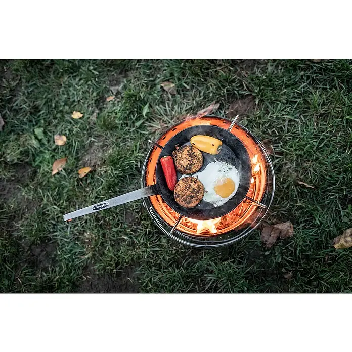 Petromax Grillpfanne - Durchmesser: 17,8 cm - 24 cm, Höhe: 12,6 cm, Eisen - Pfanne mit Spiegelei, Gemüse und Bratlingen auf einem BioLite Herd, umgeben von grünem Gras.