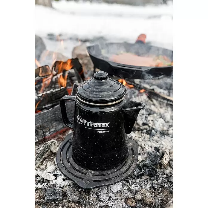 Petromax Perkolator Perkomax - Schwarz, 1,3 l - Schwarzer Petromax Perkomax Perkolator kocht auf dem Lagerfeuer, Pfanne brät im Hintergrund.