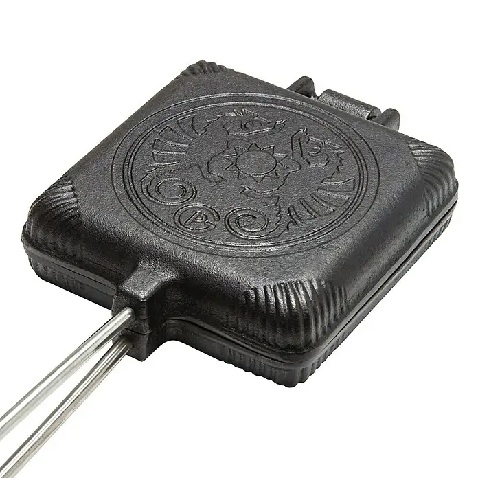 Petromax Sandwicheisen - L x B: 72,5 x 13,5 cm, Gusseisen - Nahaufnahme eines schwarzen Sandwich-Eisen mit einem verzierten Deckel und Metallgriffen. Ideal für Lagerfeuer-Snacks.