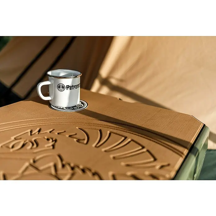 Petromax Tasse - 370 ml, Weiß - Nahaufnahme einer Petromax-Emailletasse auf einem Tisch mit geprägtem Logo.