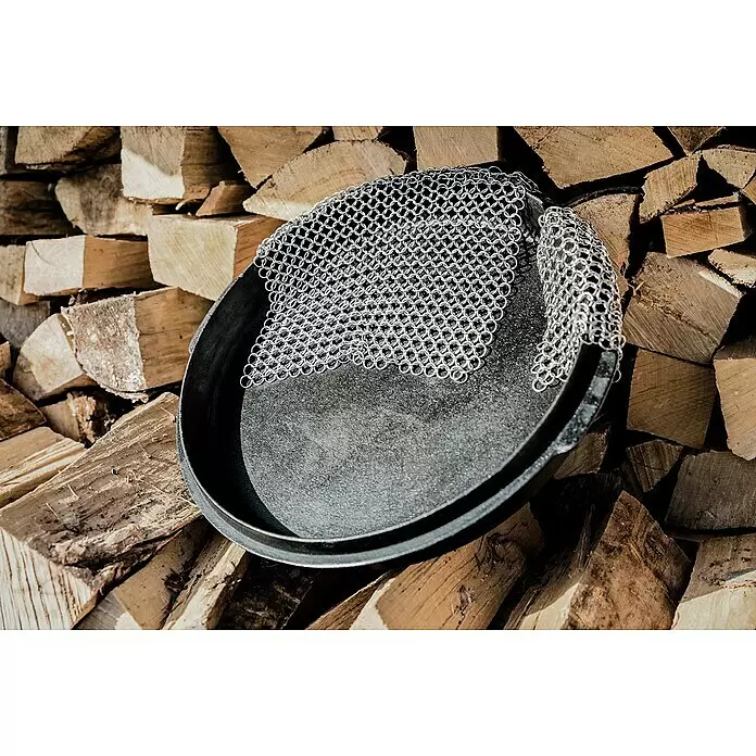 Petromax Grillreiniger Ringreiniger - 20 x 20 cm, Edelstahl - Silberner Ringgeflecht-Reiniger in Gusseisenpfanne auf Brennholz.