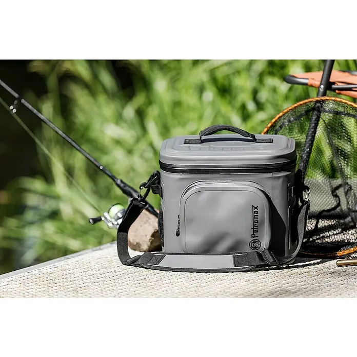 Petromax Kühltasche - Dunkelgrau, 22 l, L x B x H: 42,5 x 34 x 35,5 cm - Graue Petromax Kühltasche neben Angelrute und Kescher. Ideal für Outdoor-Aktivitäten, hält Speisen und Getränke kühl.