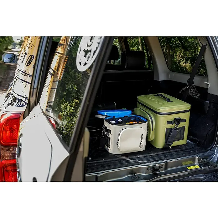 Petromax Kühltasche - Oliv, 22 l, L x B x H: 42,5 x 34 x 35,5 cm - Im Kofferraum eines Autos befinden sich zwei Petromax Kühltaschen, eine hellgraue und eine olivgrüne. Ideal für Campingausflüge!