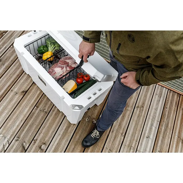 Petromax Einhängekorb - Passend für: Petromax Kühlbox 50 l, L x B x H: 23 x 36 x 14 cm, Schwarz - Ein weißer Kühlbehälter mit Lebensmitteln gefüllt, teilweise geöffnet auf einer Holzterrasse. Die Lebensmittel wirken frisch und gut gekühlt.