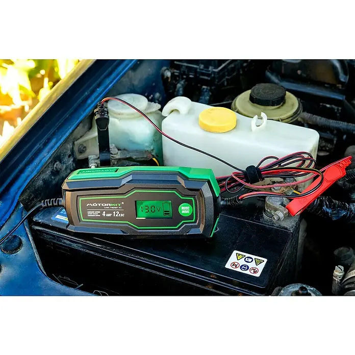 Arrancador de baterías - Capacidad: 120 Ah, 12 V - Un cargador de batería MotorKit conectado a una batería de coche, mostrando 13.0V en su pantalla.