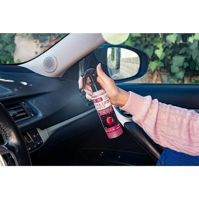 Spray ambientador de coche - Cereza, 200 ml - Interior de un coche con una persona usando un spray de cereza Paradise Scents.