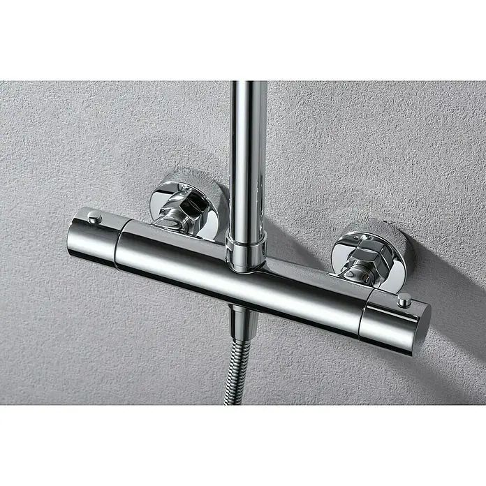 Camargue Natur Sistema de ducha - Con grifo termostático, Cromo - Primer plano de una válvula de ducha cromada con control de temperatura y barra vertical de ducha contra una pared gris.
