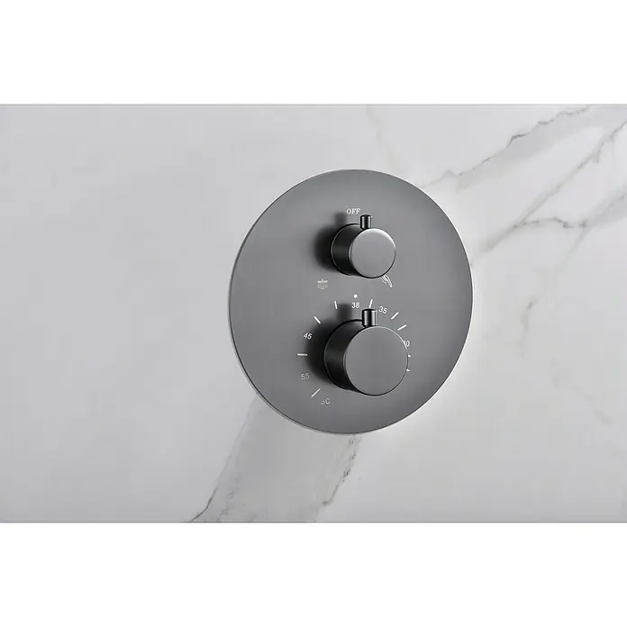 Camargue Natur Sistema de ducha empotrado - Con grifo termostático, Black Gum - Primer plano de un mezclador de ducha redondo negro mate con control de temperatura en una pared de mármol.
