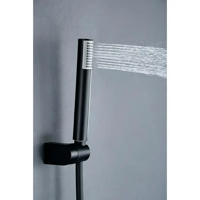 Camargue Natur Grifo monomando de ducha - Negro - Primer plano de una ducha de mano negra con chorros de agua sobre una pared gris, destacando un diseño de baño moderno.