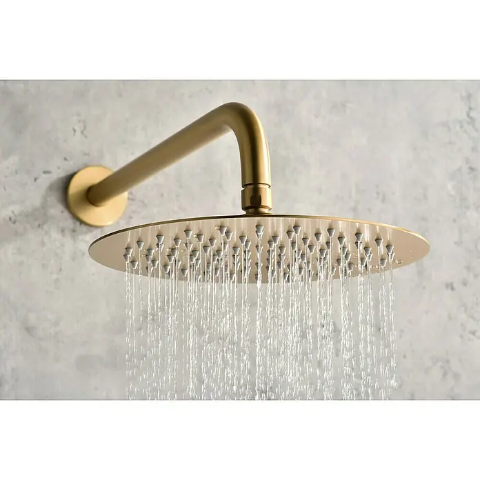 Camargue Natur Sistema de ducha empotrado - Con grifo termostático, Oro cepillado - Primer plano de un cabezal de ducha de lluvia dorado que vierte chorros de agua, creando un ambiente de baño lujoso.\n