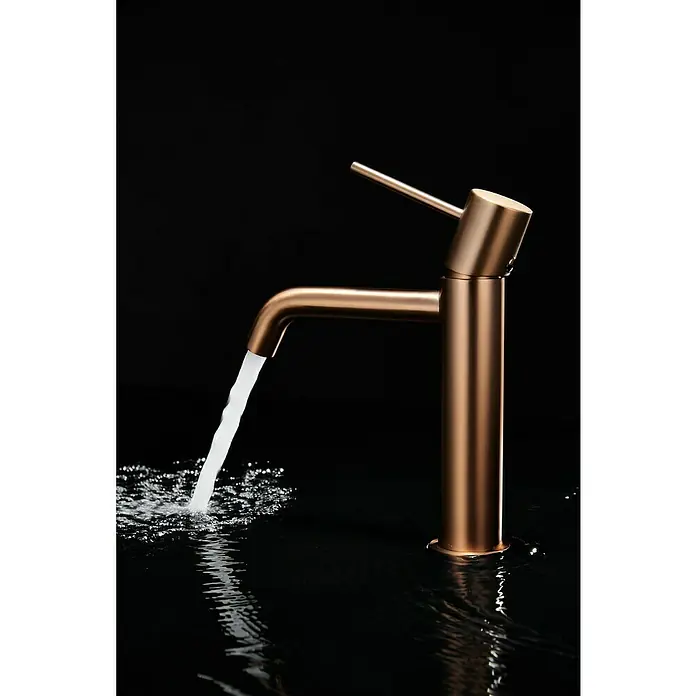 Camargue Natur Grifo de lavabo - Oro rosa - Primer plano de un grifo moderno de color bronce con agua corriente sobre un fondo oscuro. Diseño elegante y funcionalidad.