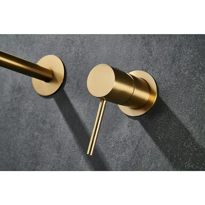 Camargue Natur Grifo de lavabo empotrado - Oro - Primer plano de un elegante grifo de baño dorado montado en una pared oscura, que muestra un diseño moderno y elegancia.