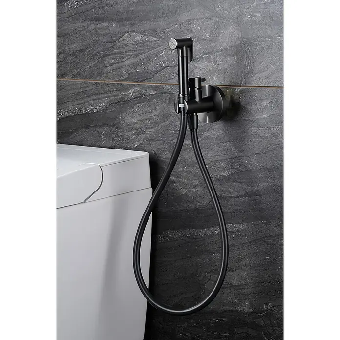 Camargue Natur Ducha higiénica inodoro - Black gun - Primer plano de una ducha de bidé negra con manguera, montada en una pared gris junto a un inodoro blanco.