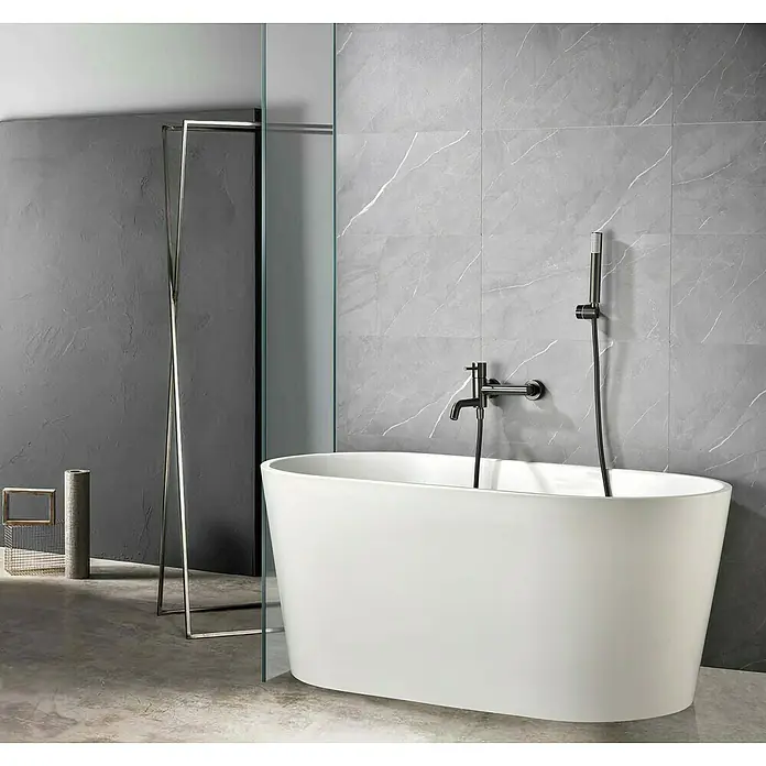 Camargue Natur Grifo monomando de bañera / ducha - Black gun metal - Bañera independiente en un baño moderno con azulejos grises y accesorios negros. La bañera es el punto focal de la habitación.