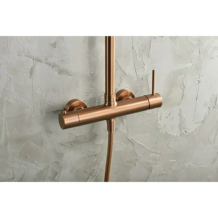 Camargue Natur Sistema de ducha - Con grifo monomando, Oro rosa - Grifo de ducha color cobre con mezclador termostático horizontal fijado a una pared gris.