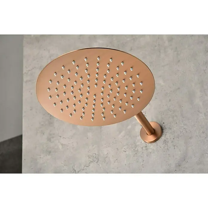 Camargue Natur Sistema de ducha empotrado - Con grifo termostático, Oro Rosa - Primer plano de un cabezal de ducha moderno, redondo y en tono cobre, con boquillas blancas sobre un fondo gris.