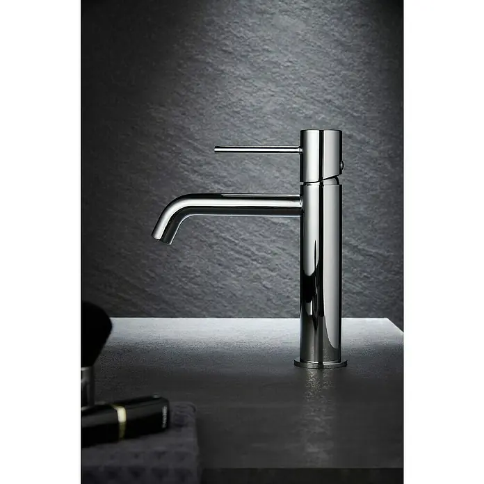 Camargue Natur Grifo de lavabo - Cromo - Primer plano de un moderno grifo de baño cromado con un diseño minimalista, sobre un fondo oscuro y texturizado.