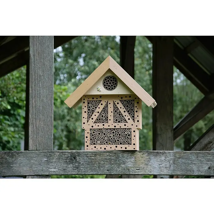 Dobar Insektenhotel Monschau - L x B x H: 37,5 x 15 x 38,5 cm, Natur - Nahaufnahme eines Insektenhotels aus Holz mit Röhren zum Nisten, das auf einer Holzkonstruktion im Freien steht.