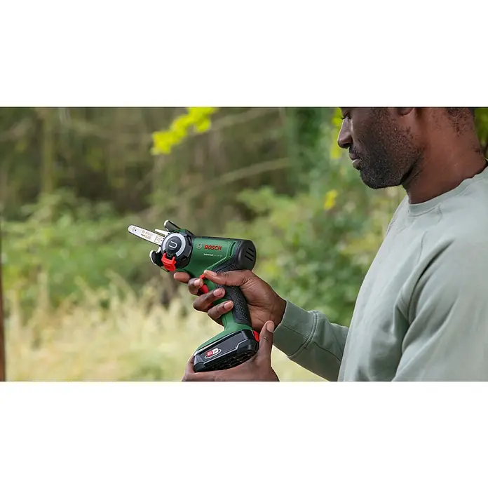 Bosch Power for All 18V NanoBlade-Säge Universal Cut 18V-65 - 18 V, 1 Akku, 2,5 Ah, 0 U/min - 8.000 U/min - Ein Mann hält die Bosch Akku-Kettensäge UniversalChain 18V-20 in seinen Händen, bereit für den Einsatz im Garten.