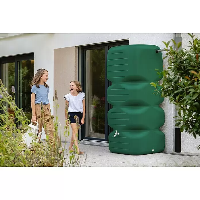 Garantia Basic Line Regentonne Cubus - 1.000 l, Dunkelgrün - Grüner Regentonne mit Hahn am Haus, ein Kind hält eine Gießkanne bereit, um Wasser für Pflanzen zu sammeln.